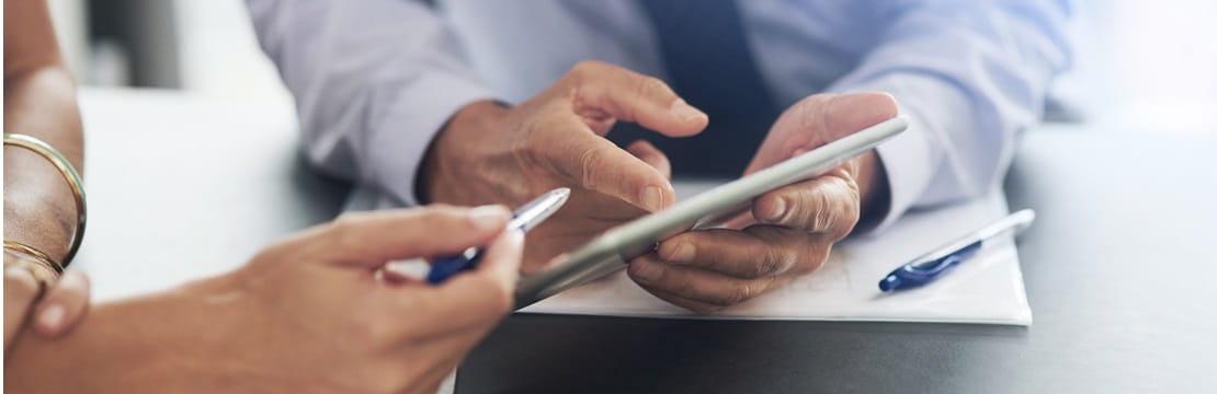 Close-up of two people's hands reviewing documents.